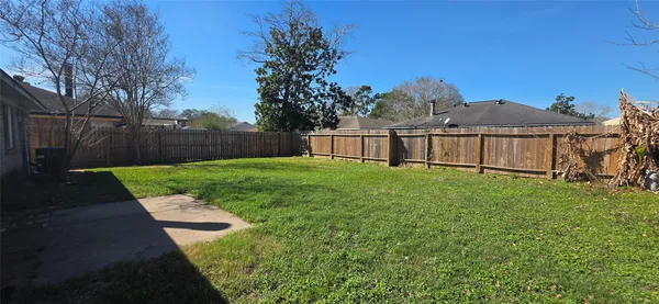 a view of a yard with wooden fence