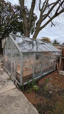 a view of a backyard with wooden fence and a large tree