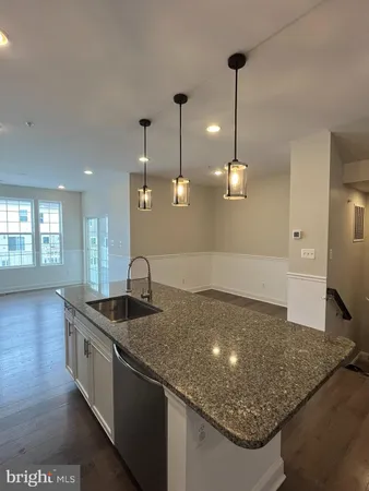 a kitchen with stainless steel appliances granite countertop a refrigerator a sink a stove and oven with wooden floor