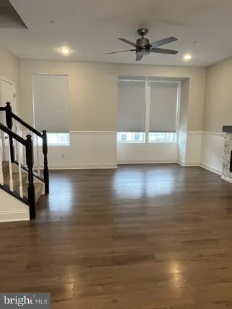a view of empty room with wooden floor and fireplace