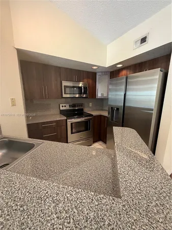 a kitchen with stainless steel appliances kitchen island granite countertop a stove a sink and a microwave