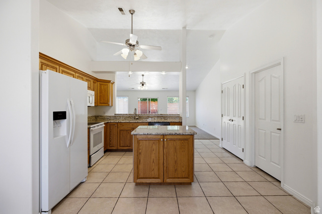 1630 East 2450th Street South, Unit 263 St. George, UT 84790 - Photo 7 of 24 Kitchen featuring light wood cabinetry, granite-finish countertops, tile flooring, and a central island