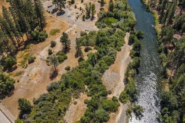 an aerial view of a house with a yard and lake view