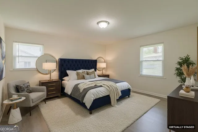 a bedroom with a bed wooden floor and window