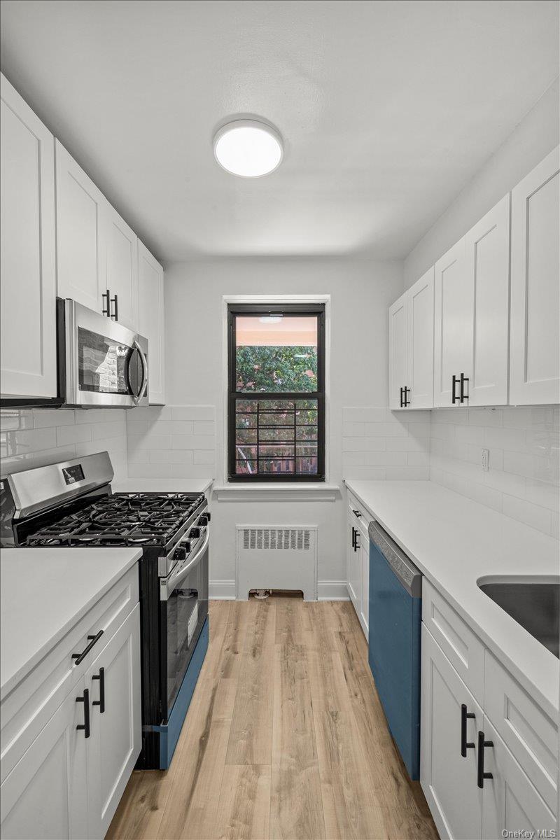 3635 Johnson Avenue, Unit 4M Bronx, NY 10463 - Photo 11 of 21 a open kitchen with stainless steel appliances granite countertop a stove a sink and white cabinets