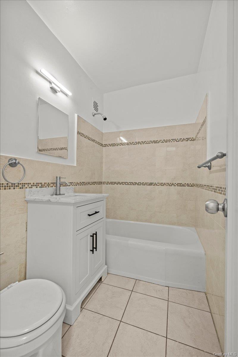 3635 Johnson Avenue, Unit 4M Bronx, NY 10463 - Photo 16 of 21 a bathroom with a granite countertop toilet a sink and bathtub