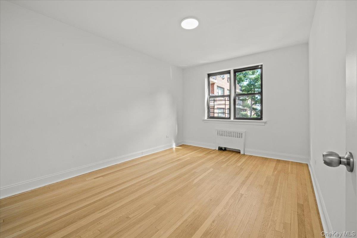 3635 Johnson Avenue, Unit 4M Bronx, NY 10463 - Photo 17 of 21 an empty room with wooden floor and windows