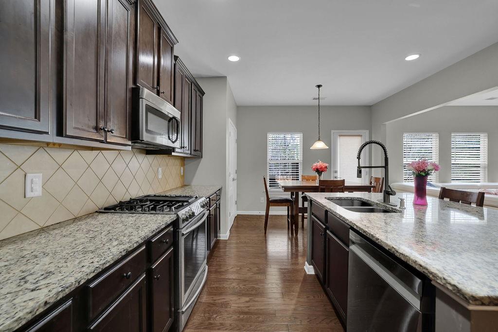 333 Nobleman Way Canton, GA 30114 - Photo 14 of 31 a kitchen with granite countertop stainless steel appliances a sink stove top oven and cabinets