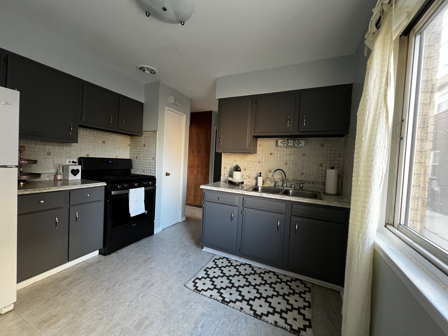 8653 Niles Center Road, Unit D Skokie, IL 60077 - Photo 2 of 8 a kitchen with a sink stove and refrigerator