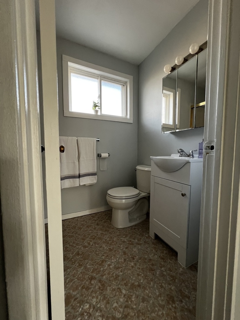 8653 Niles Center Road, Unit D Skokie, IL 60077 - Photo 7 of 8 a bathroom with a toilet sink and a mirror