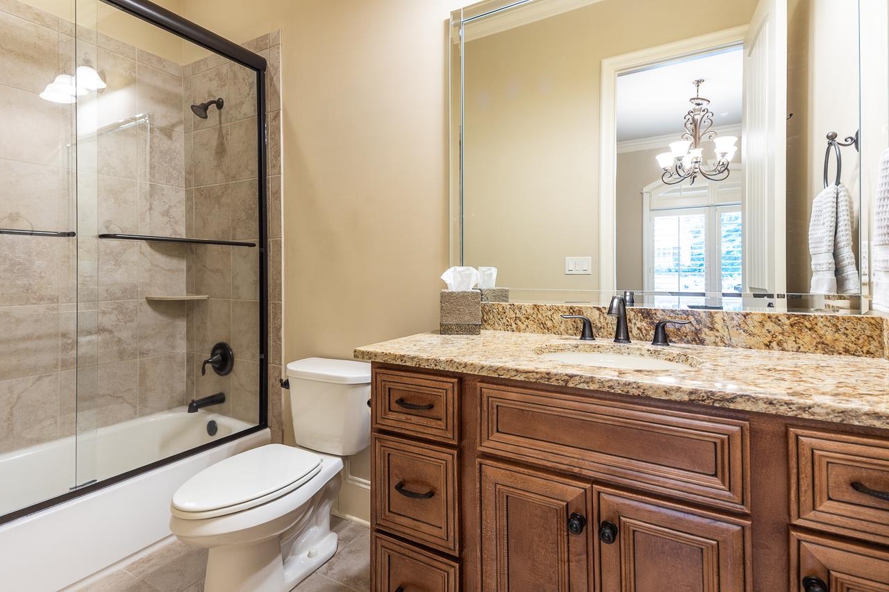 4600 Maple Glen Court Lakeland, TN 38002 - Photo 24 of 40 a bathroom with a granite countertop toilet a sink and a mirror