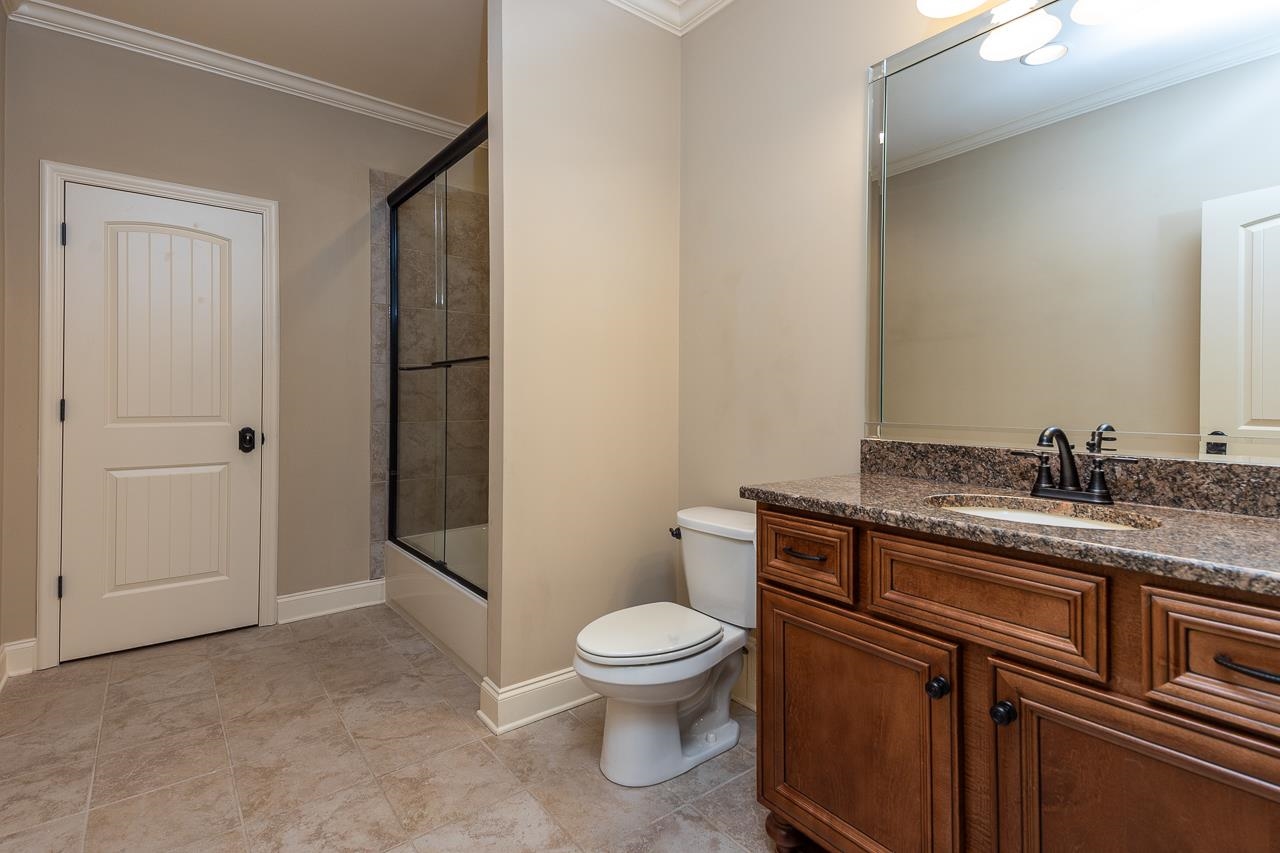 4600 Maple Glen Court Lakeland, TN 38002 - Photo 29 of 40 a bathroom with a granite countertop toilet a sink and a mirror