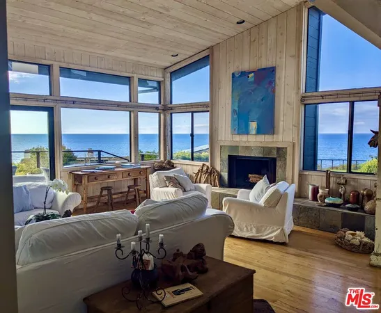 a living room with furniture fireplace and a large window