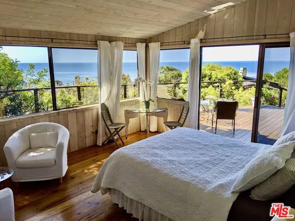 a bedroom with a bed and large windows