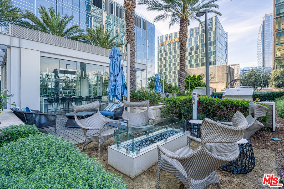 877 Francisco Street, Unit 1906 Los Angeles, CA 90017 - Photo 18 of 31 a view of a patio with couches table and chairs potted plants and palm tree