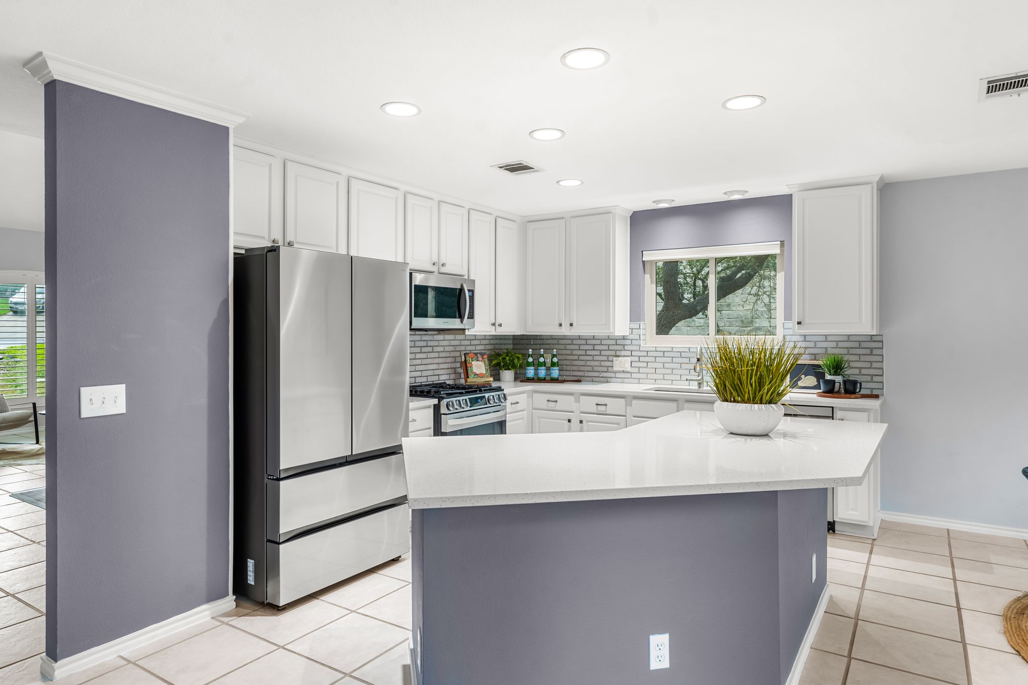 3704 Caney Creek Road Austin, TX 78732 - Photo 9 of 40 A pristine culinary space features sleek stainless steel appliances, abundant white cabinetry, and bright recessed lighting.