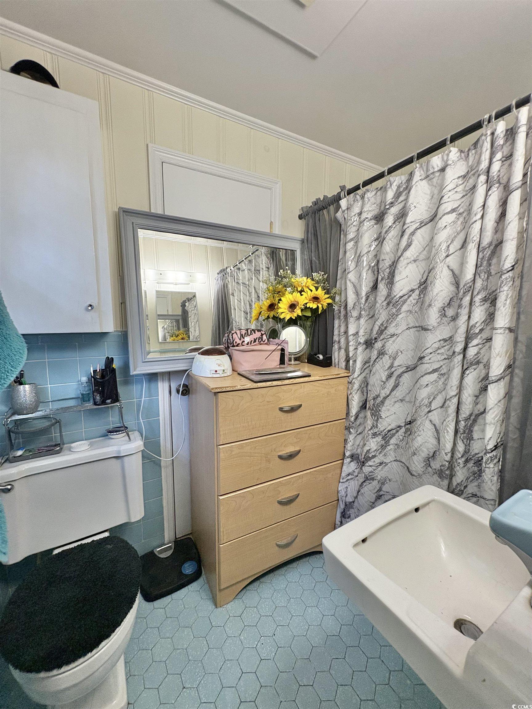 520-526 Boundary Avenue Murrells Inlet, SC 29576 - Photo 27 of 38 Bathroom with light tile patterned floors, curtained shower, vanity, decorative backsplash, and tile walls