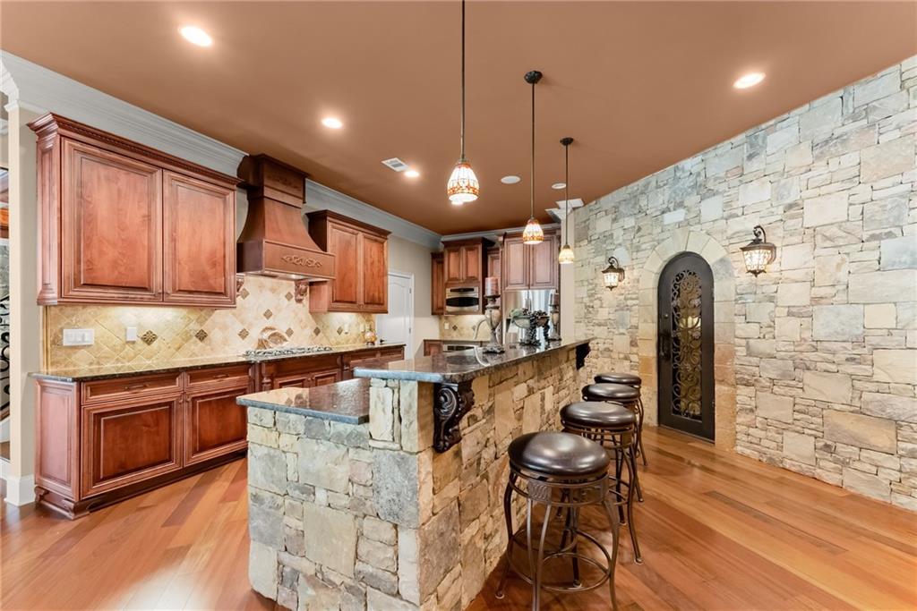 1310 Settles Road Suwanee, GA 30024 - Photo 49 of 71 a kitchen with stainless steel appliances granite countertop a sink a stove and a wooden floors