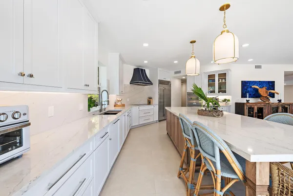 a large kitchen with kitchen island a large counter space a sink appliances and cabinets
