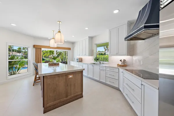 a kitchen with kitchen island granite countertop lots of counter top space and wooden floor