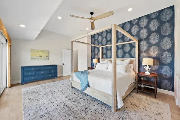 a large bedroom with a bed and wooden floor