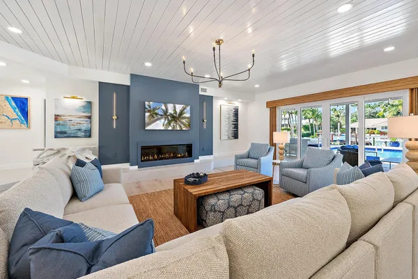 a living room with furniture a large window and a flat screen tv