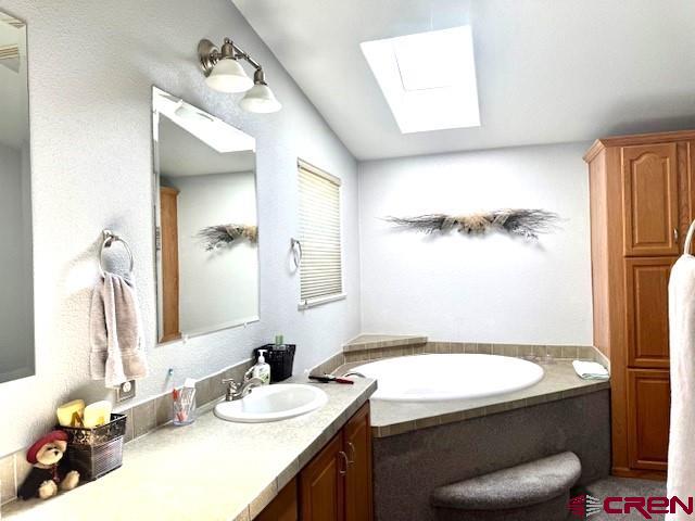 802 Bluffs Boulevard Cortez, CO 81321 - Photo 13 of 30 a bathroom with a granite countertop sink a toilet and a mirror