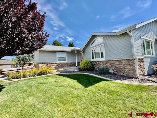802 Bluffs Boulevard Cortez, CO 81321 - Photo 20 of 30 a front view of house with yard and green space