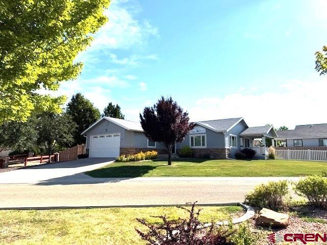 802 Bluffs Boulevard Cortez, CO 81321 - Photo 2 of 30 a front view of a house with a garden and yard