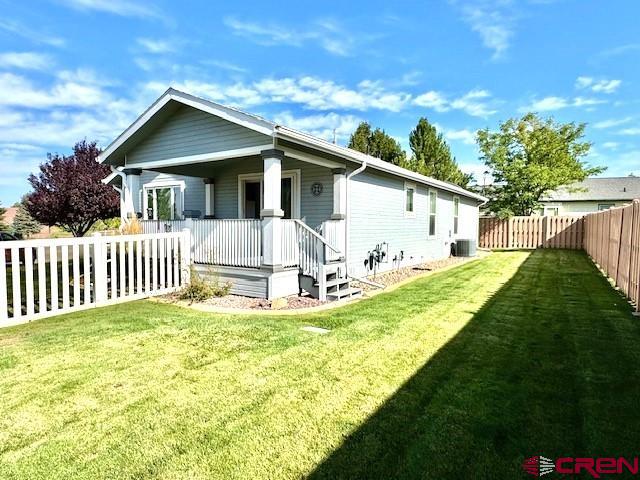 802 Bluffs Boulevard Cortez, CO 81321 - Photo 23 of 30 a white house that has a small yard and large trees