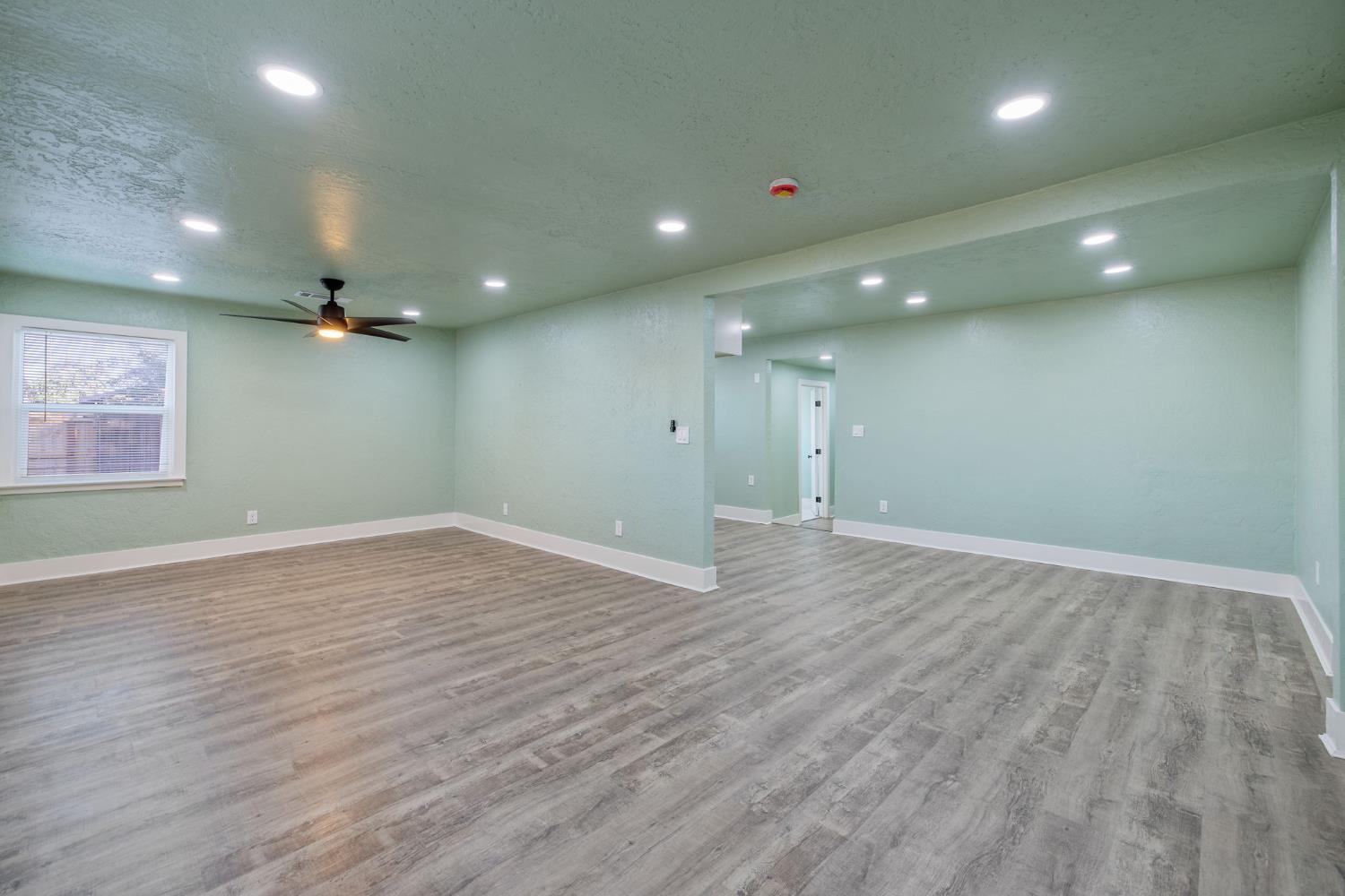 4722 East Florence Avenue Fresno, CA 93725 - Photo 10 of 51 an empty room with wooden floor and windows
