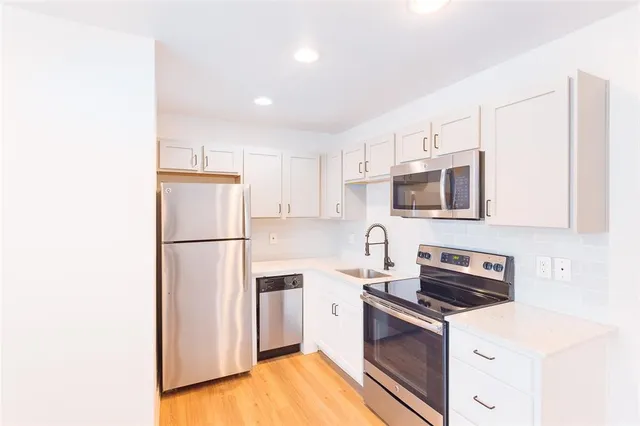 a kitchen with stainless steel appliances a refrigerator stove microwave and sink