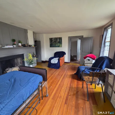 a bedroom with furniture and a wooden floor