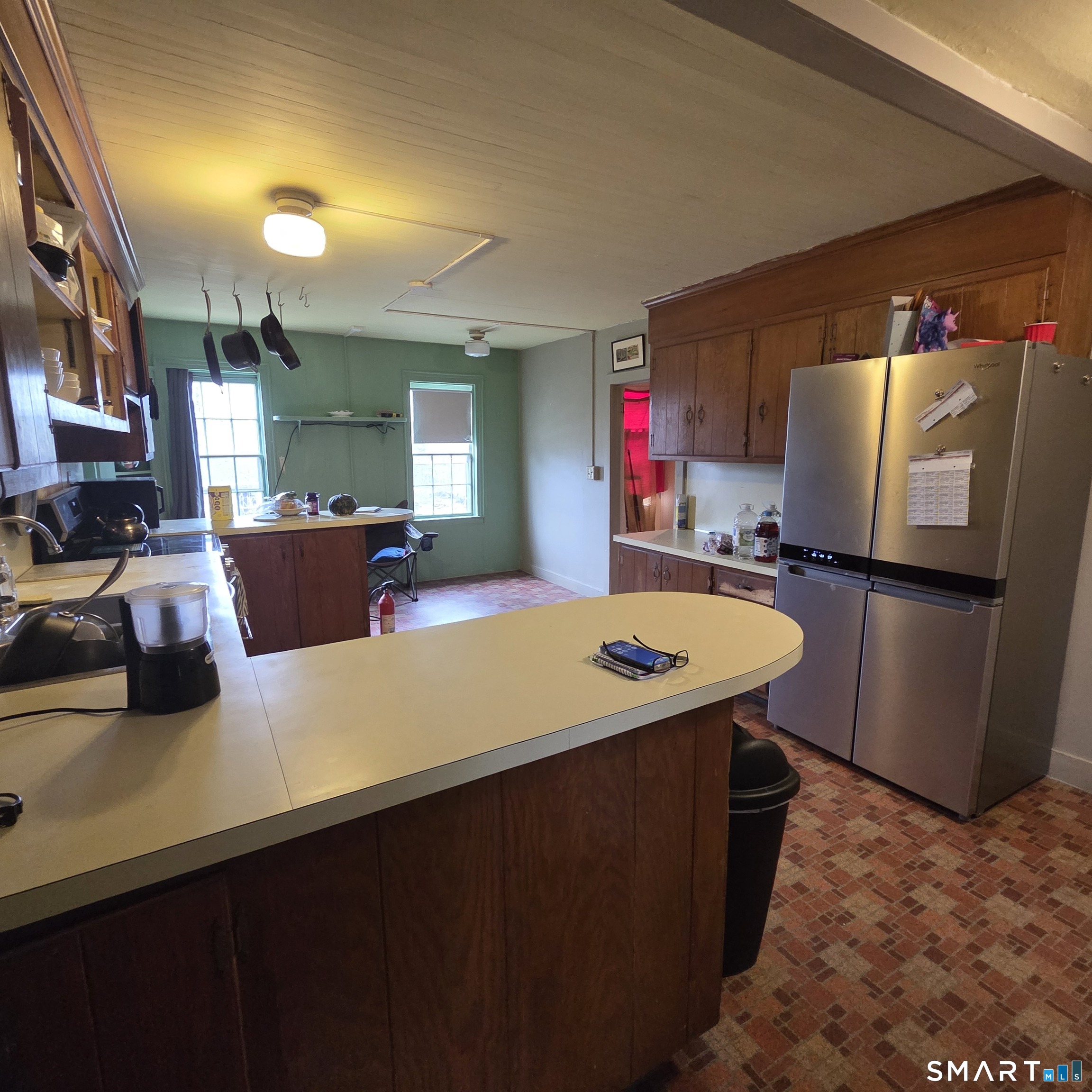 26 Plains Road Windham, CT 06280 - Photo 15 of 32 a kitchen with stainless steel appliances a stove a refrigerator a sink and a dining table with wooden floor