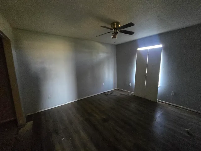 a view of a big room with wooden floor and windows