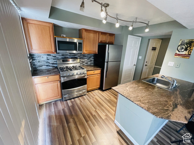 2220 East Murray Holladay Road, Unit 146 Holladay, UT 84117 - Photo 1 of 1 Kitchen featuring stainless steel appliances, a sink, light wood-style flooring, tasteful backsplash, and dark countertops