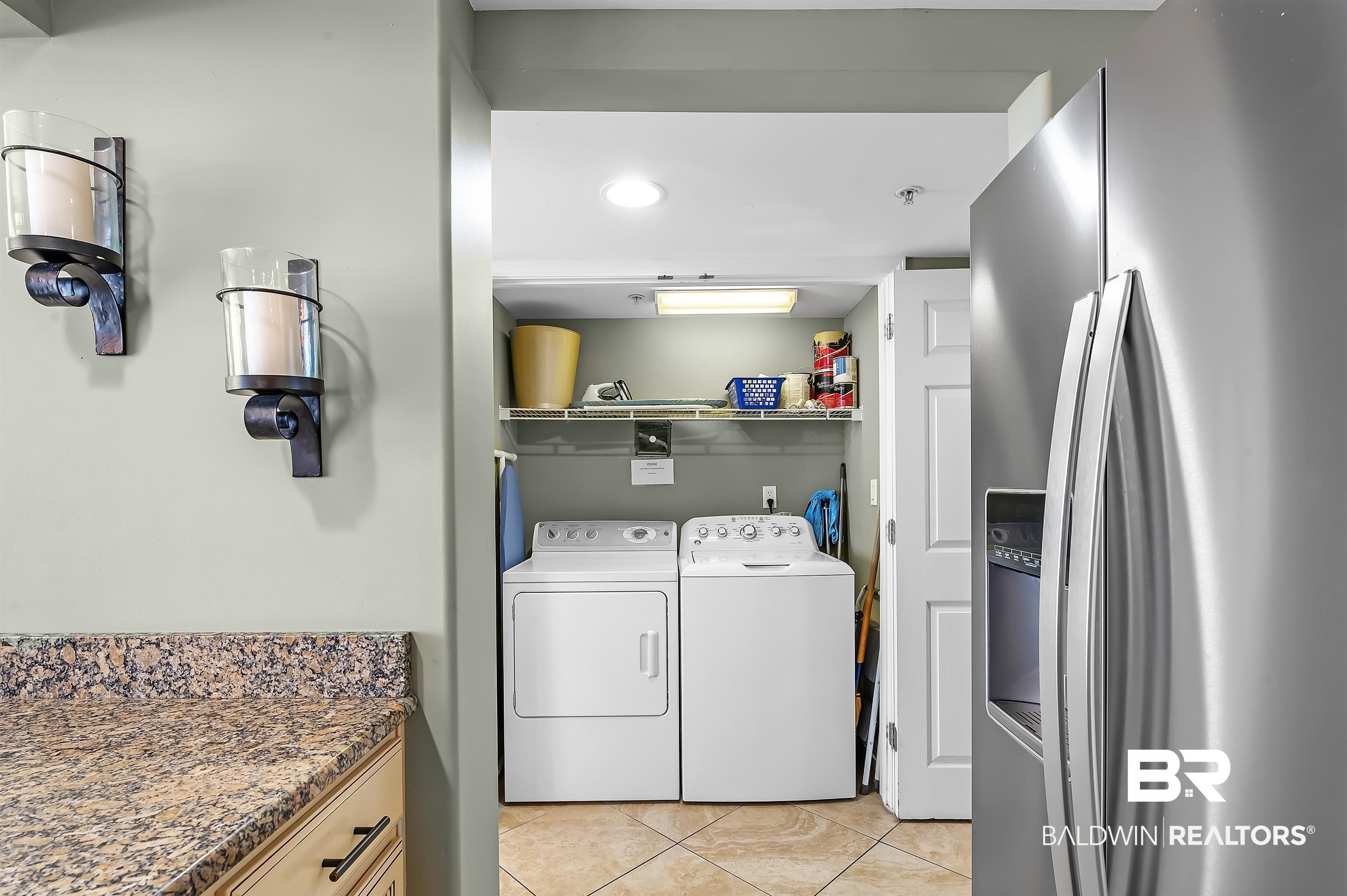 16287 Perdido Key Drive, Unit 105 Pensacola, FL 32507 - Photo 25 of 66 Dedicated laundry area featuring a white washer and dryer, tile flooring, and integrated shelving