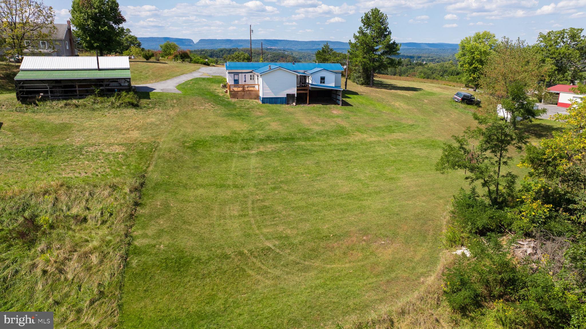5386 Pious Ridge Road Berkeley Springs, WV 25411 - Photo 13 of 20 a view of a swimming pool with a yard and a bench