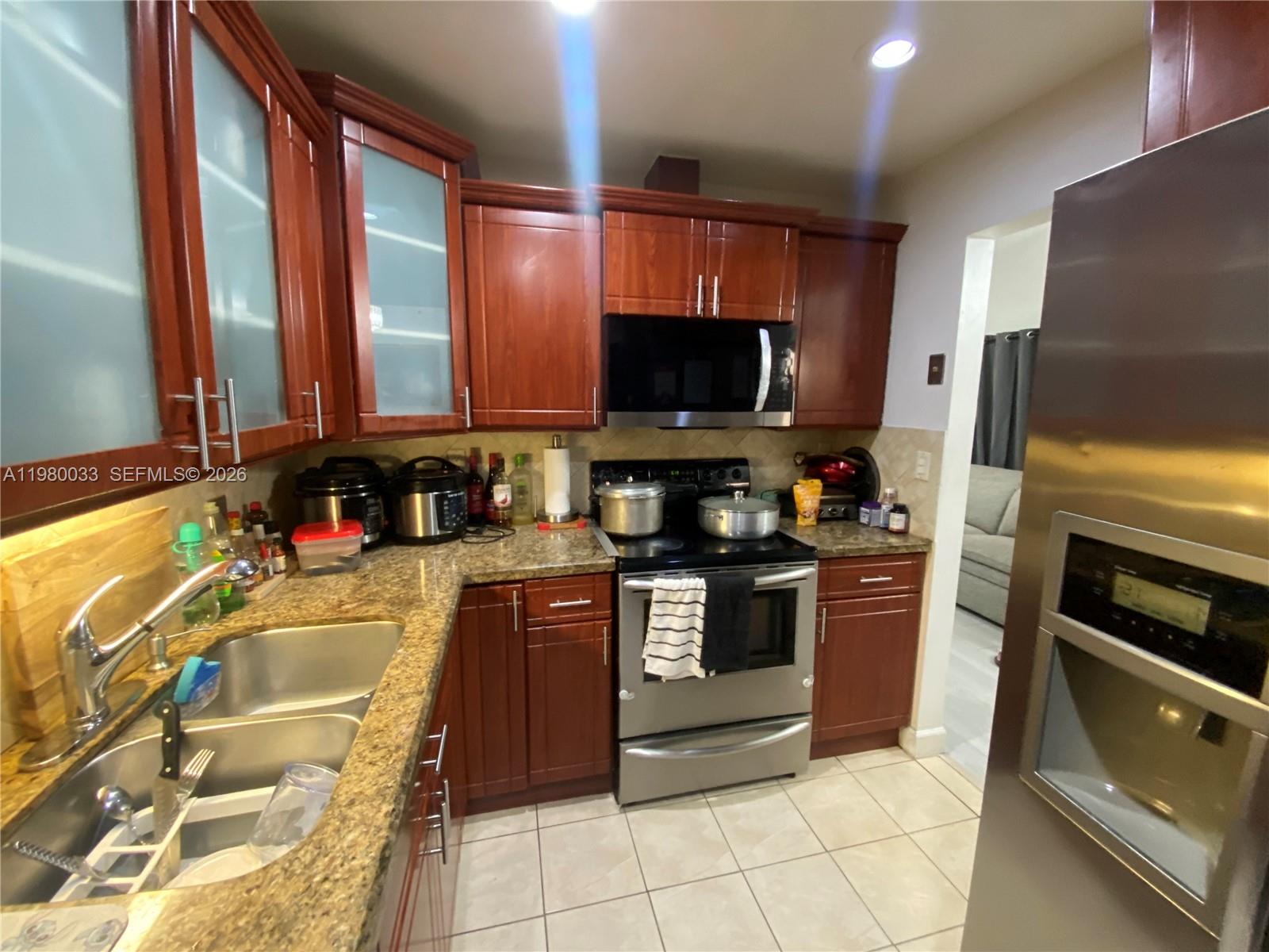 13815 Southwest 54th Street Miami, FL 33175 - Photo 11 of 23 a kitchen with stainless steel appliances a stove a sink and a microwave