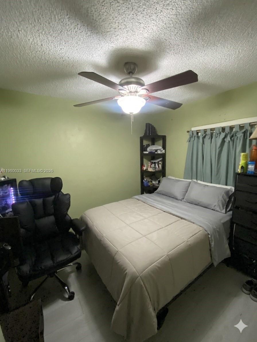 13815 Southwest 54th Street Miami, FL 33175 - Photo 13 of 23 a bedroom with a bed and a chandelier