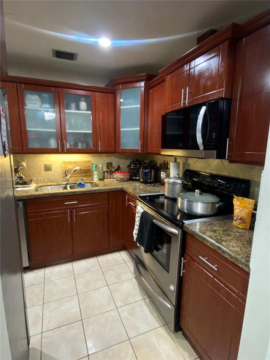 13815 Southwest 54th Street Miami, FL 33175 - Photo 7 of 23 a kitchen with a sink stove top oven and cabinets