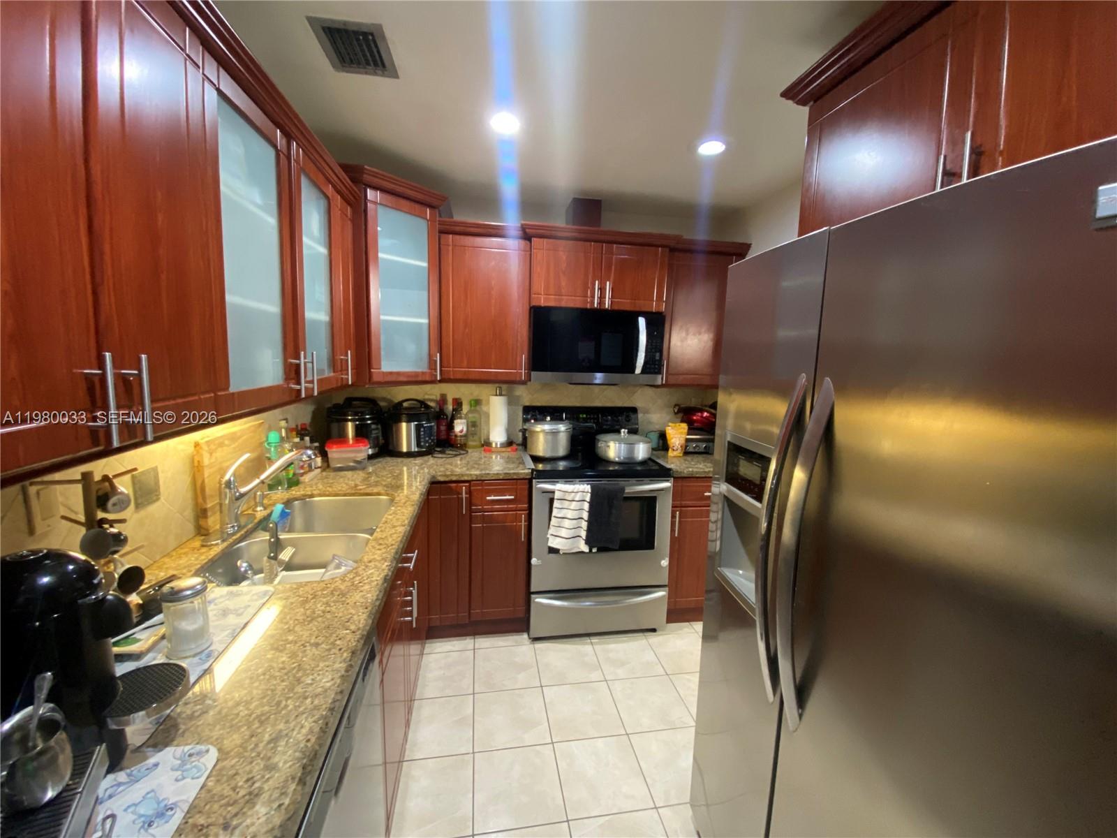 13815 Southwest 54th Street Miami, FL 33175 - Photo 10 of 23 a kitchen with stainless steel appliances granite countertop a refrigerator a stove and a sink