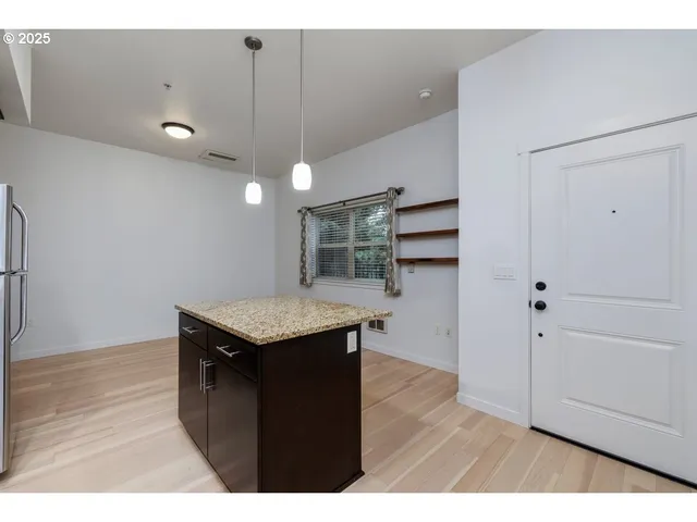 a kitchen with stainless steel appliances granite countertop a refrigerator a stove top oven a sink and dishwasher