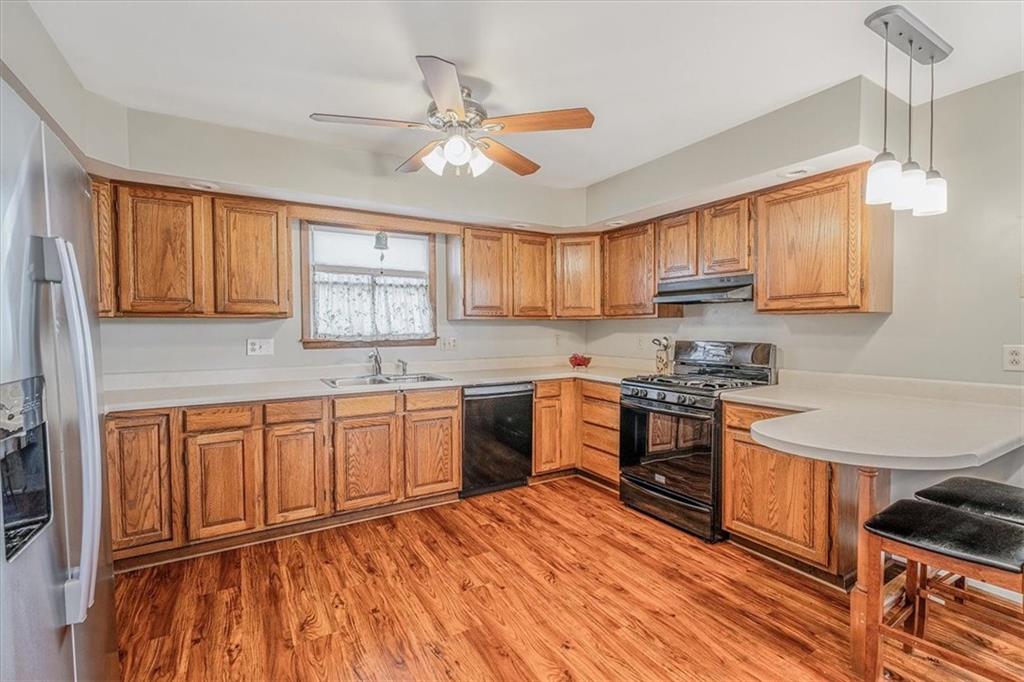 206 Washington Street Beaver, PA 15009 - Photo 15 of 32 a kitchen with stainless steel appliances granite countertop wooden cabinets a sink a stove a refrigerator and island with wooden floor