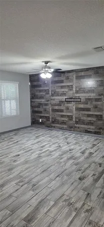 a view of empty room with window and wooden floor