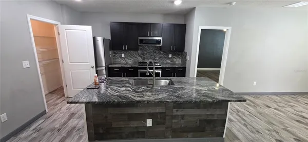 a kitchen with kitchen island stainless steel appliances a sink and a stove