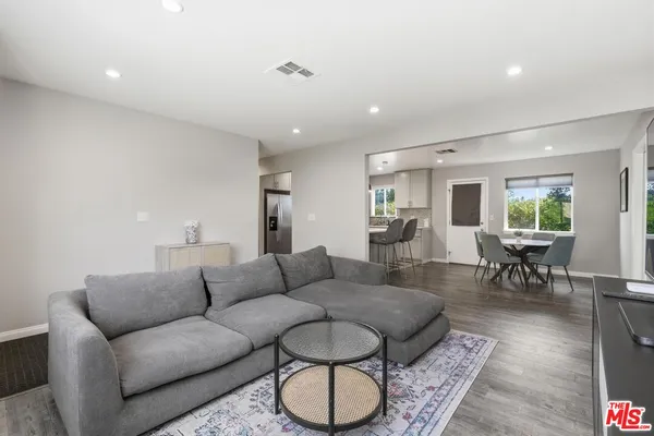 a living room with furniture potted plant and a wooden floor