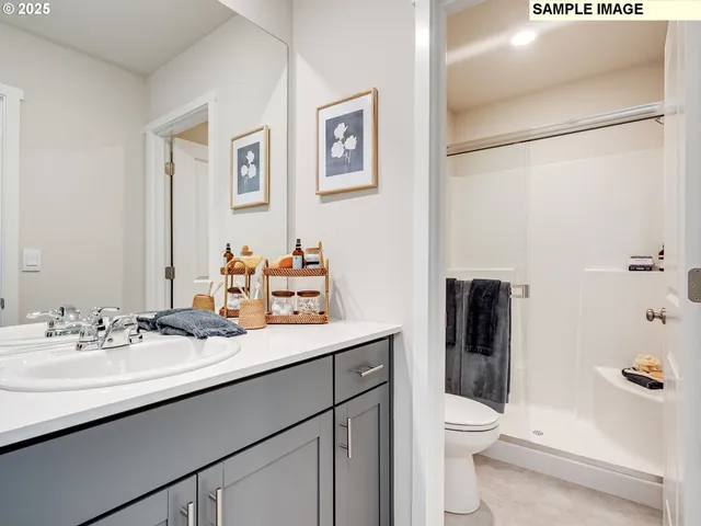 a bathroom with a sink a toilet a shower and a mirror