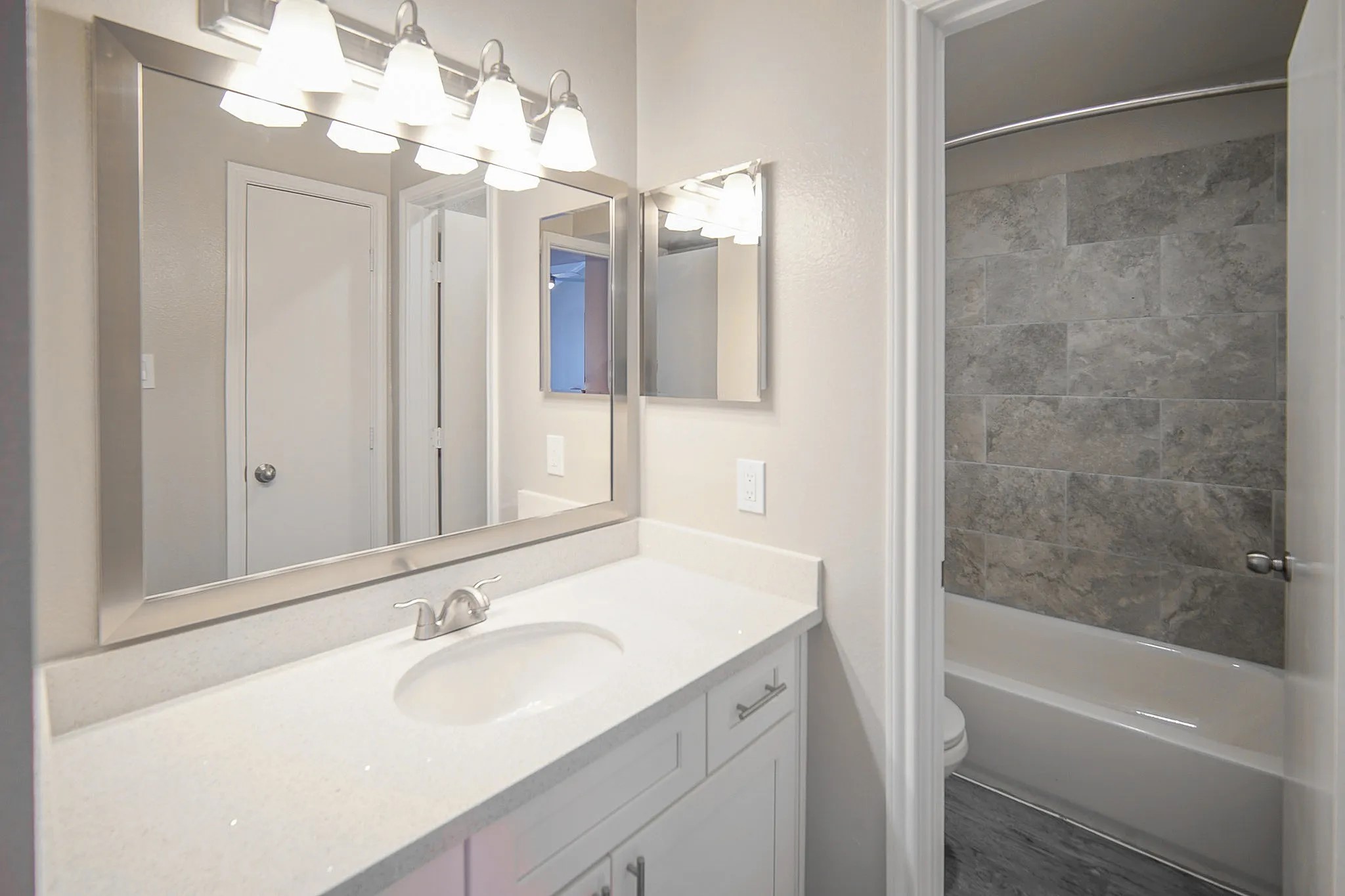 8455 Will Clayton Parkway, Unit 103 Humble, TX 77338 - Photo 11 of 23 a bathroom with a sink vanity granite tub shower and a mirror