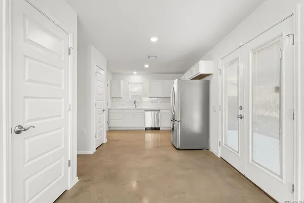 a kitchen with white cabinets and white appliances